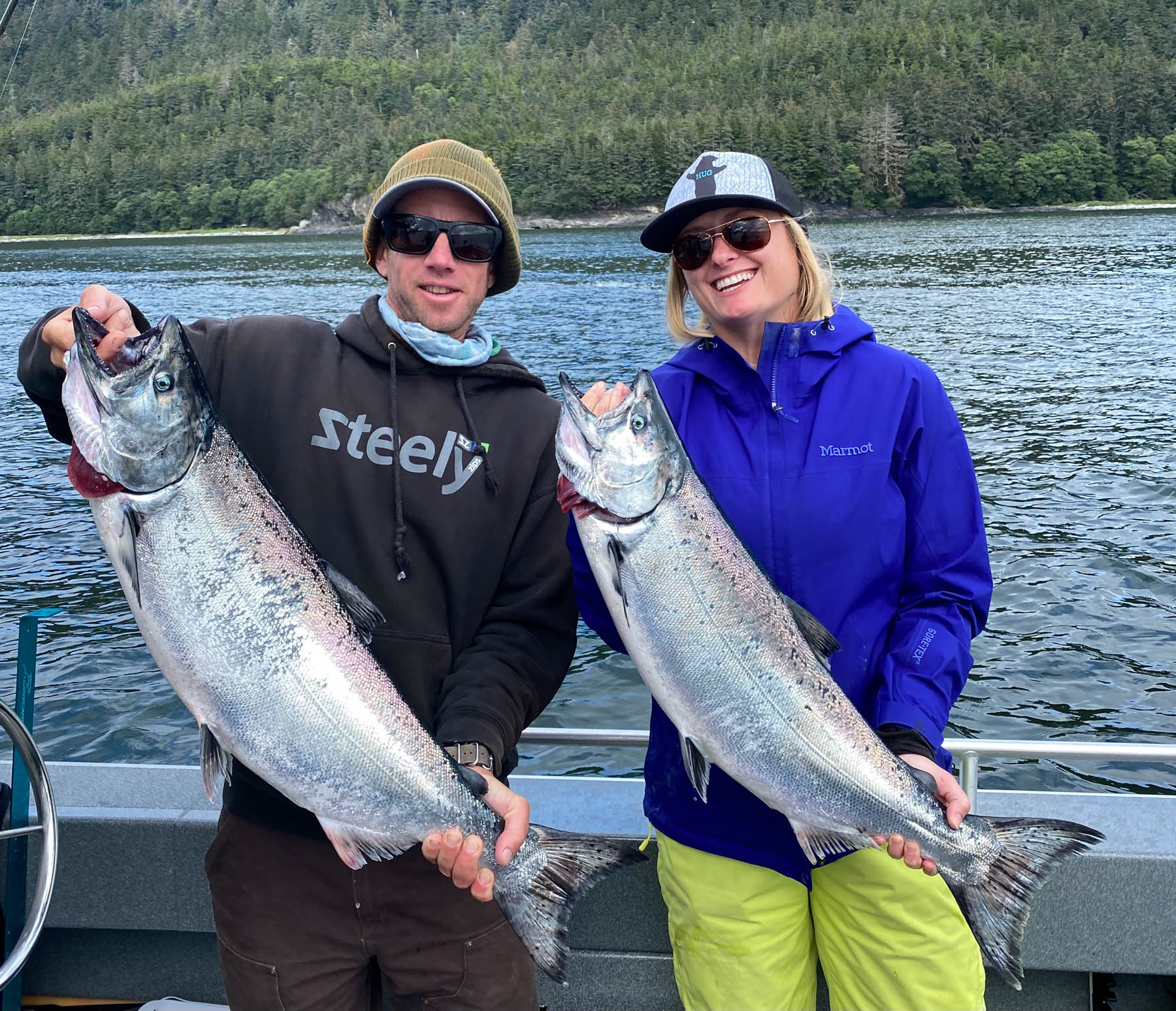 Happy guests holding large King salmon caught during a Juneau Alaska fishing trip.