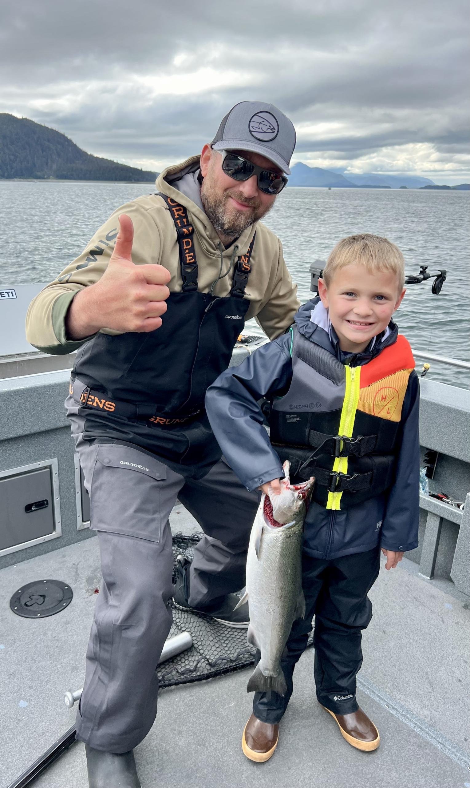 A very happy guests holding his first coho caught on a private fishing charter in Juneau, Alaska with Adventures in Alaska.